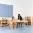 round wooden table in classroom with teacher chair