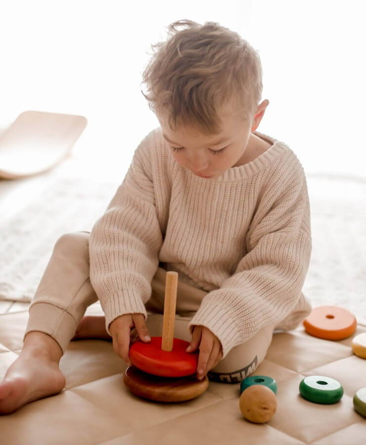 child playing with qtoys stacking rings