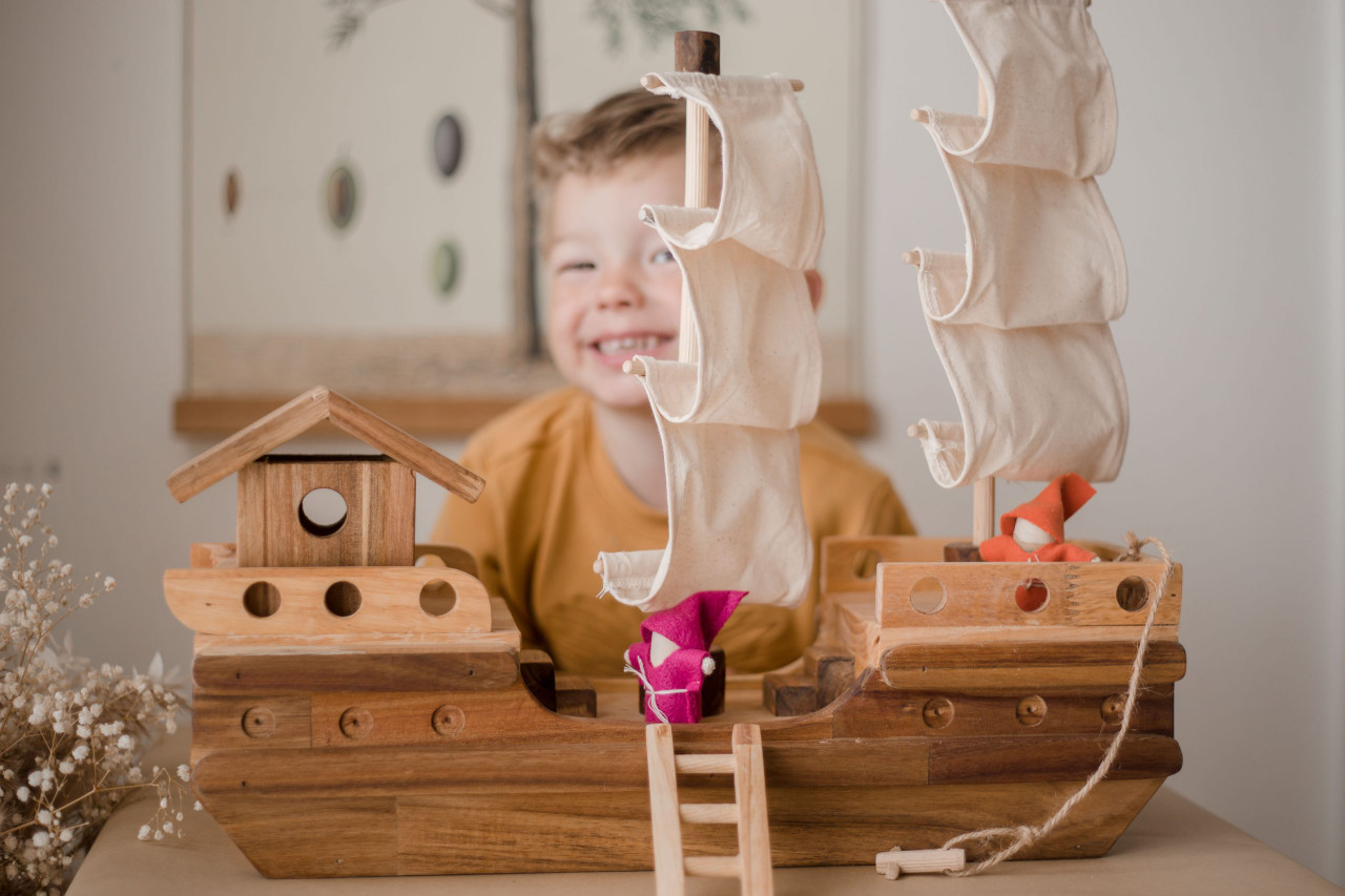 boy playing with qtoys wooden pirate ship