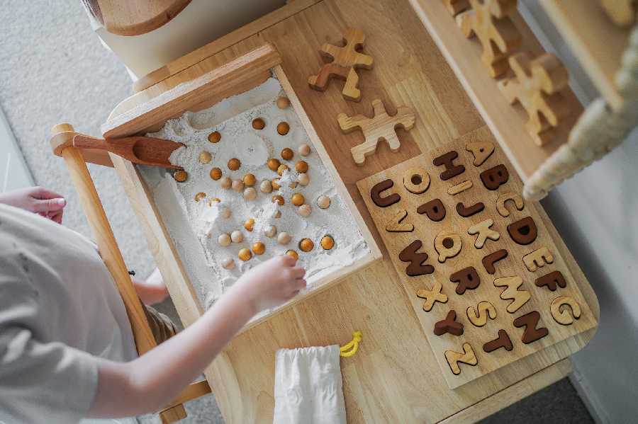 child playing with wooden alphabet puzzle child playing with wooden alphabet puzzle
