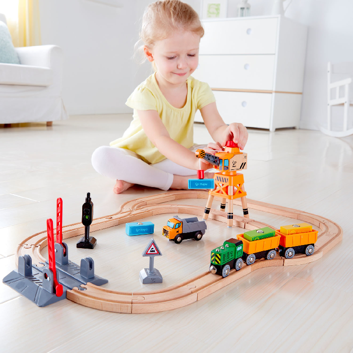 child playing with hape crossing and crain railway set child playing with hape crossing and crain railway set