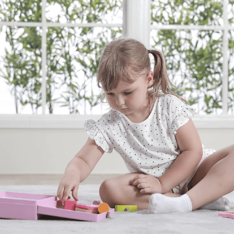 girl playing with wooden beauty set
