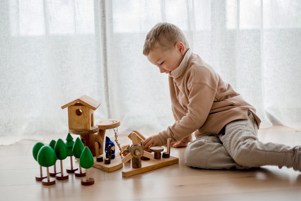 Child playing with Qtoys Wooden Tree Play Set Child playing with Qtoys Wooden Tree Play Set