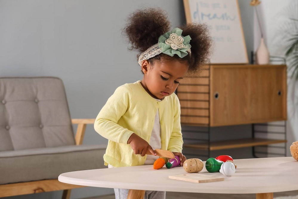 Child playing with Viga Cutting Vegetable Playset