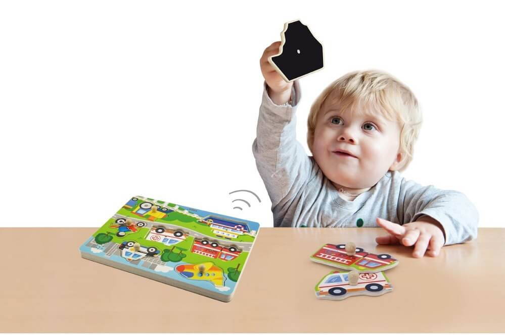 Toddler playing with Viga Sound Puzzle - Transportation