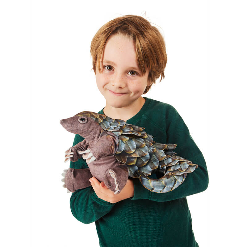 Child holding Folkmanis pangolin puppet
