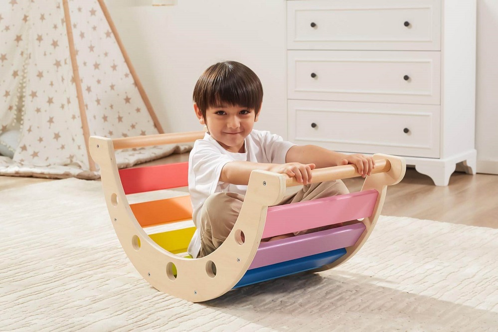 Child on board the Viga Wooden Rainbow Rocker boat