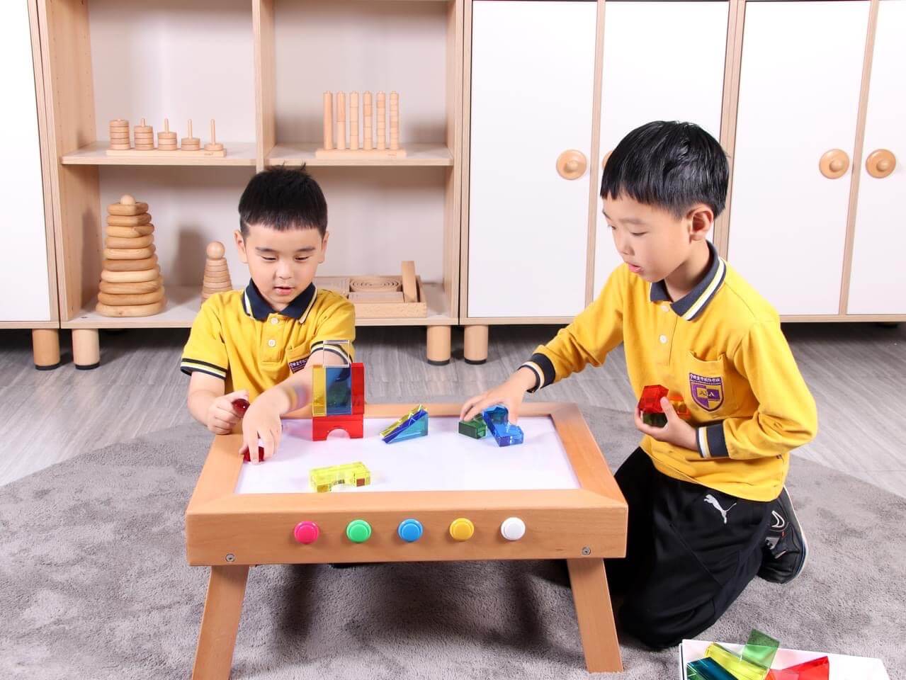 kids playing with acrylic blocks on light table