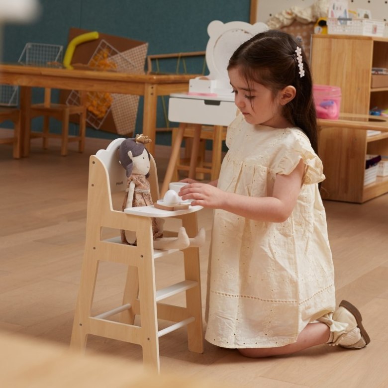 girl playing with modern doll high chair