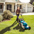 Person mowing a lawn with a Makita cordless lawn mower, lifestyle photo