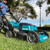 Makita cordless lawn mower parked on grass in a backyard, lifestyle photo