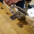 Close-up drilling action with chips around stainless dowelling jig