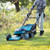 Person pushing Makita cordless self-propelled mower while cutting grass, lifestyle photo