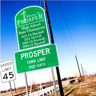 Welcoming visitors and locals to its affluent town is this Prosper city limits sign. Being that Prosper is a rather small town, residents pride is even larger which is why the local high schools state champion titles are also featured here.