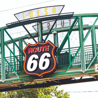 A Route 66 sign on the pedestrian bridge on 11st Street at Cyrus Avery Plaza in Tulsa Oklahoma. A tribute and memorial to this historic piece of Americana.
