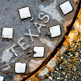 Presenting its rustic charm, this Texas manhole embodies the varying characteristics of the state as a whole.