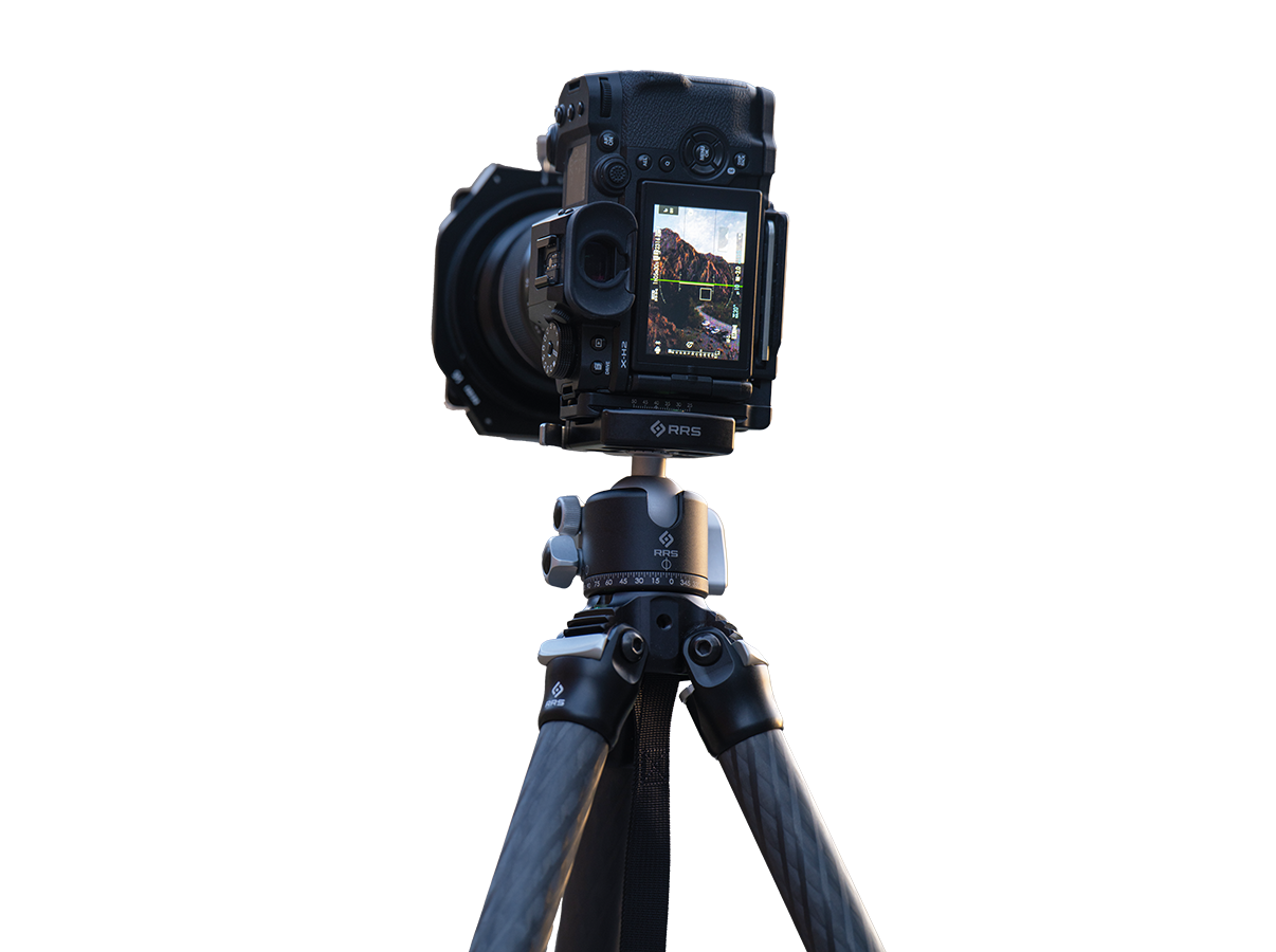 Night or blue-hour landscape on uneven ground with wide tripod leg stance, showing solid apex and BH-40 head with minimal visible flex points