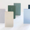 Byfulldesign Notable Memory Long Weekly Planners standing upright in pastel and dark colors, with textured covers and subtle lettering.