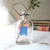 Glass vase decorated with a blue ribbon paper sticker