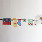 Miniature paper stickers hanging on a small branch