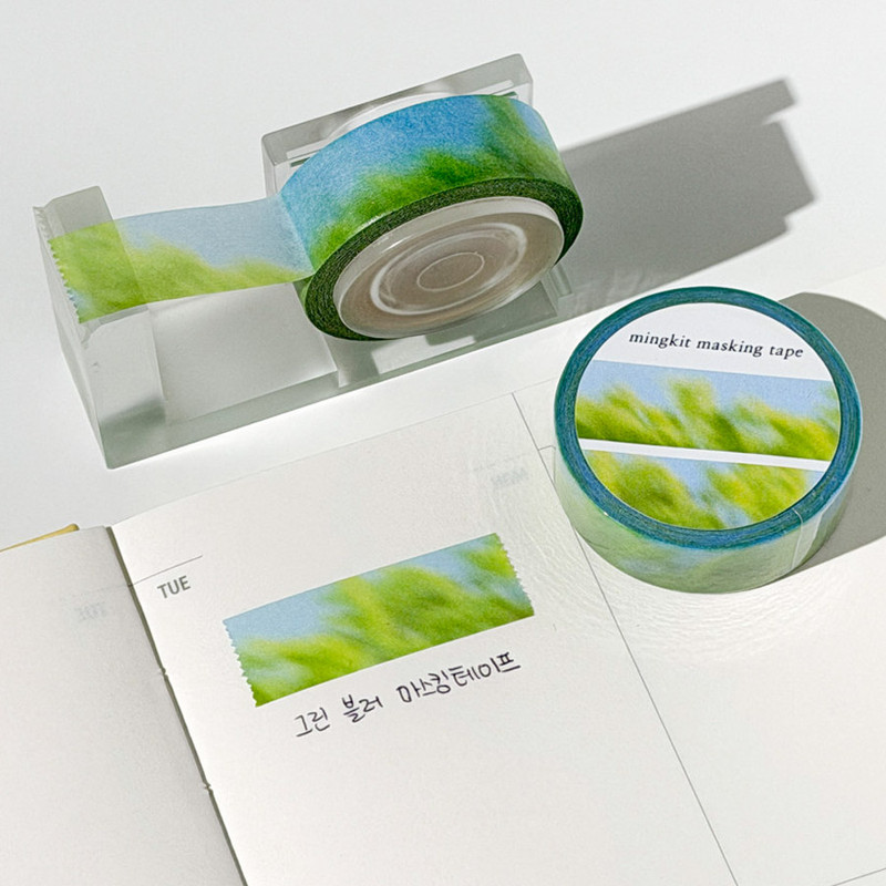 Mingkit Green Blur washi tape beside a planner page decorated with a strip of the tape