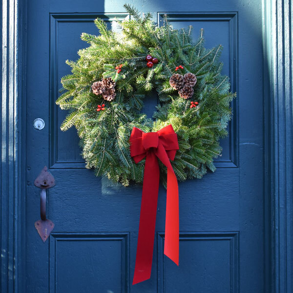 wreath with red bow on blue door