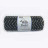 Rolled charcoal grey sherpa fleece blanket with a label, Danish Design.