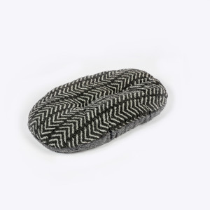 Charcoal and white chevron patterned dog bed, oval shape, fleece material, angled view.