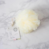 Urbana Spa Prive Body Buffer, luxurious white body buffer sponge on a marble surface with a tag attached.