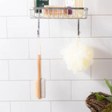 Urbana Spa Prive Body Buffer, bath sponge and bath brush hanging from a shower rack in a bathroom.