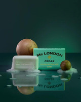 Wavertree & London Mr London Cedar Soap Bar - 10oz (280g), green soap bar with embossed logo surrounded by foam, with cedarwood scent, alongside two cedarwood spheres and a green box in the background.