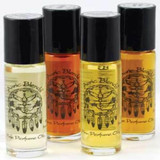 Auric Blends Stella Blue Roll-On Perfume Oil - 1/3 oz, collection of four small glass bottles with black caps containing different colored perfume oils in yellow, orange, and clear shades.