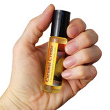 Shadow Scents Caramel Creme Perfume Oil, 1/3 oz. roll-on, being held in a hand.