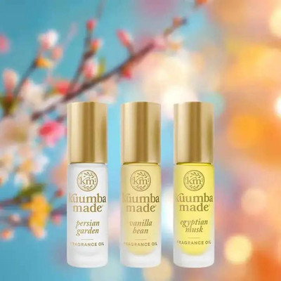 Kuumba Made Customer Favorites Collection - 3 assorted 0.15 oz fragrance oils, displayed in small bottles with gold caps against a colorful blurred background.