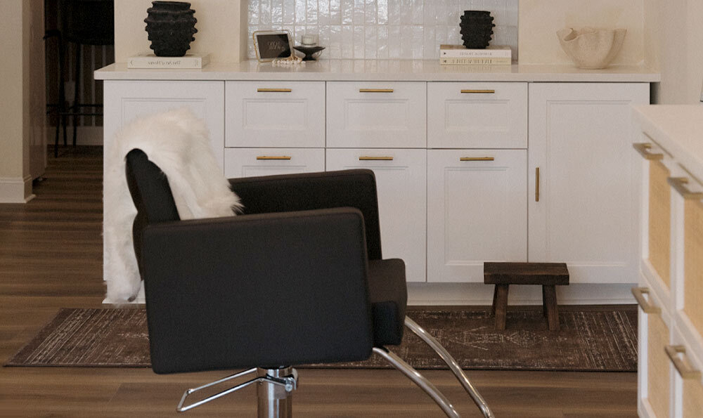 Black salon styling chairs in front of white salon styling stations in lifestyle setting