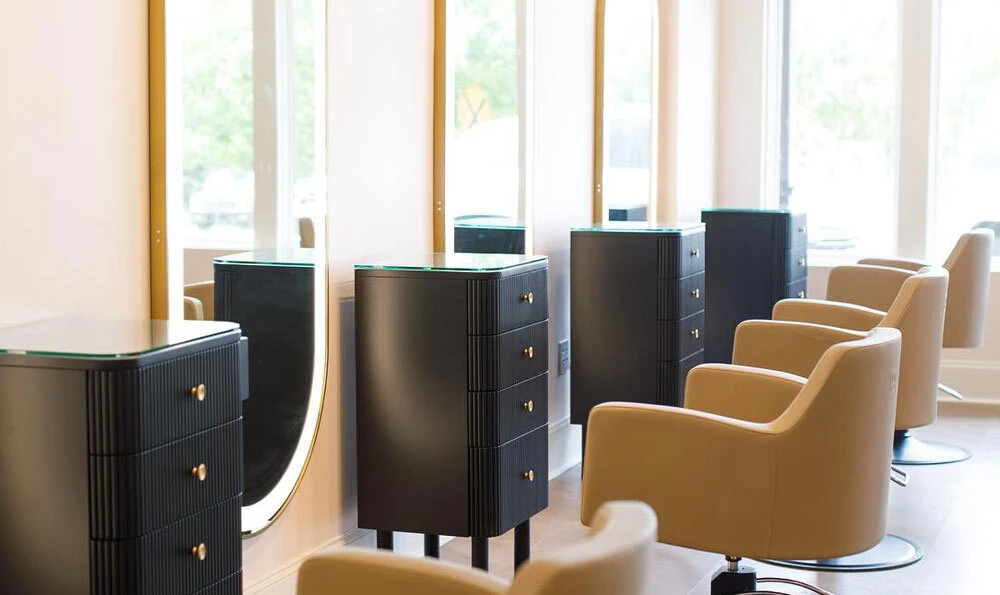 Knoll styling stations in black with saddle Venturi styling chairs and gold Avalon LED mirrors