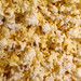 Close-up macro texture of handcrafted butterfly popcorn glazed in warm golden movie theater butter and sea salt.