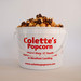 Colette's Popcorn 1-gallon jumbo bucket filled with handcrafted copper-kettle caramel popcorn drizzled with rich dark chocolate.