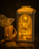 The Enchanted Room solar art lantern glowing next to a kraft gift box with gold ribbon and a for you gift tag