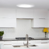 Flush-mount, round skylight accessory on a white kitchen ceiling.