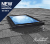 Solatube low-profile skylight on a shingled roof, reflecting blue sky.