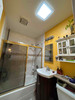 Bathroom interior with Solatube 14-inch square skylight providing natural light.
