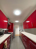 Two Solatube TierDrop Acrylic Fixtures illuminating a modern kitchen with red cabinets.