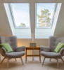 Two Solatube Premium Fixed Skylights illuminate an attic room with armchairs.