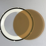 Solatube Warm Effect Lens: Round translucent amber lens next to a white circular frame with mesh.
