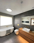 Bathroom interior featuring a Solatube Classic Vusion Diffuser, a circular skylight accessory, illuminating the space.