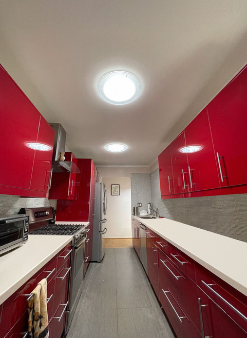 Two Solatube TierDrop Acrylic Fixtures illuminating a modern kitchen with red cabinets. Two Solatube TierDrop Acrylic Fixtures illuminating a modern kitchen with red cabinets.