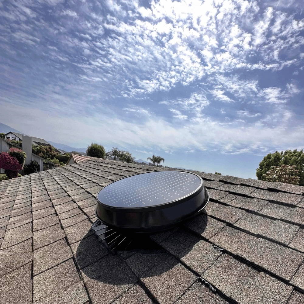 Low-profile Solatube solar attic fan installed on a low-slope tile roof