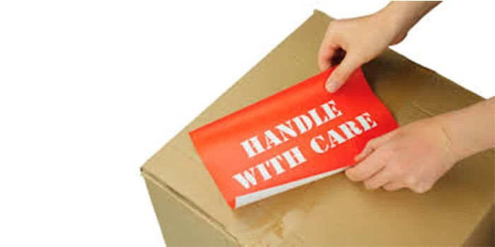 Applying handle with care tape onto parcel box