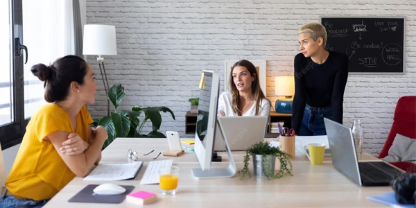 Teams collaborating around workspace table